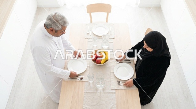 Emirati Couple Preparing Dining Table in Modern Home