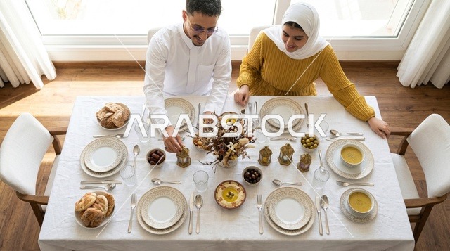 زوجان سعوديان على مائدة إفطار رمضان مع أطعمة تقليدية