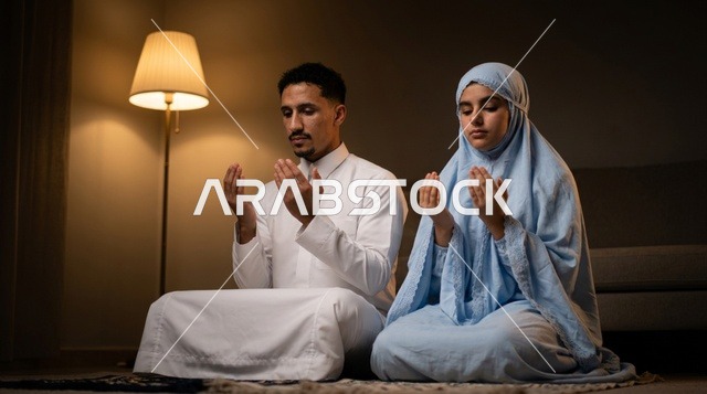 زوجان سعوديان يقومان بالدعاء والصلاة في الليل