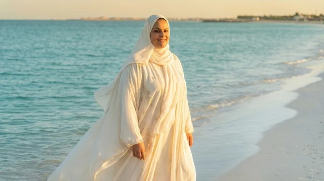 Arab Woman in White Abaya Walking on Beach at Sunset