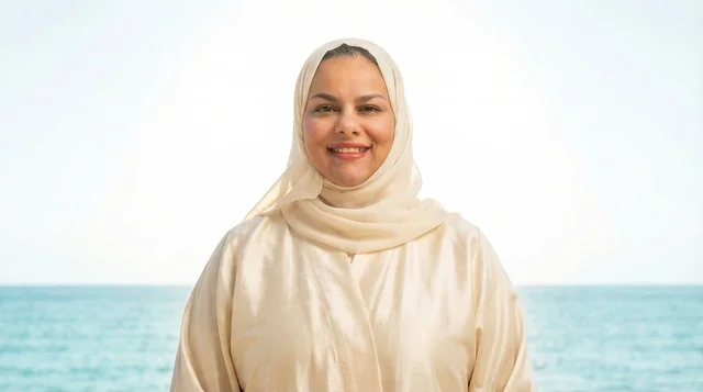 امرأة إماراتية بالعباءة والشيلة على شاطئ البحر