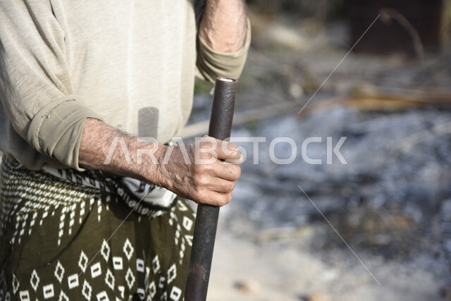 صورة لرجل عربي، فلاح يستخدم فأس لتقطيع خشب الأشجار، مزرعة ومزارعين، مهن قديمة، شعبيات