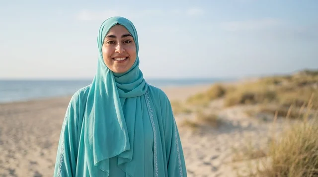 امرأة عربية بالحجاب الفيروزي على شاطئ مشمس