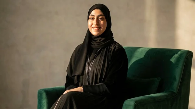 امرأة سعودية بالعباءة السوداء تجلس على كرسي مخملي