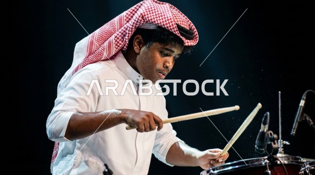 شاب سعودي يعزف على الدرامز فوق المسرح