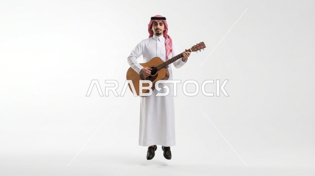رجل سعودي يقفز أثناء العزف على الجيتار بخلفية بيضاء