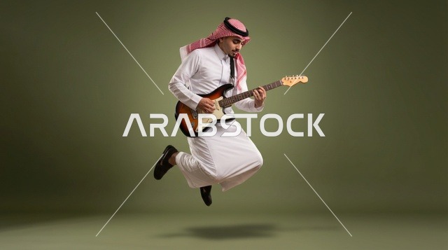 رجل سعودي يقفز ويعزف الجيتار الكهربائي في استوديو