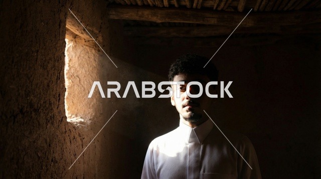 شاب سعودي بالثوب التقليدي داخل بيت طيني تراثي