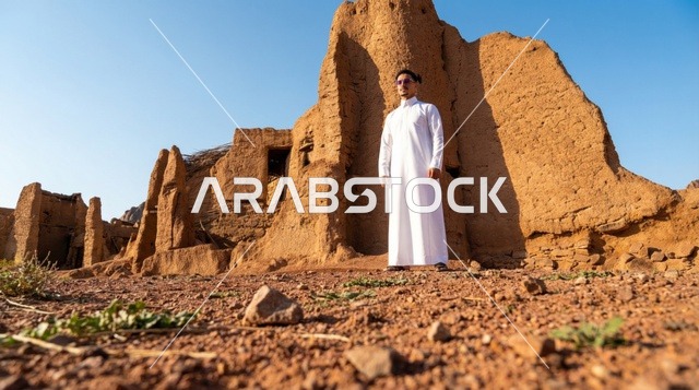 رجل سعودي بالثوب التقليدي في موقع تراثي صحراوي