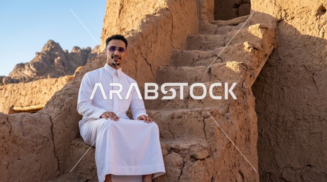 رجل سعودي بالثوب التقليدي في بيت طيني تراثي