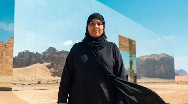 امرأة سعودية أمام مبنى مرايا في صحراء العلا بالمملكة