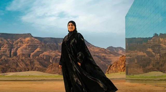 امرأة سعودية أمام مبنى مرايا في صحراء العلا