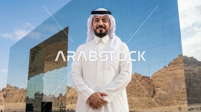 رجل سعودي أمام قاعة مرايا في العلا وقت الغروب