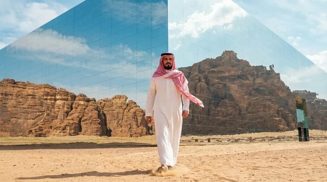 رجل سعودي أمام قاعة مرايا في صحراء العلا