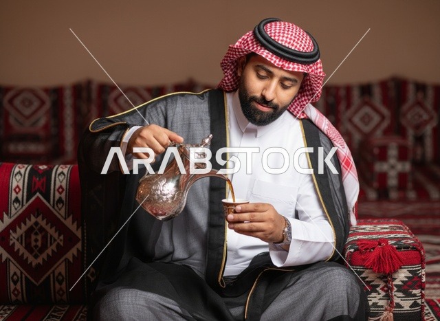 رجل سعودي يصب القهوة العربية في مجلس تقليدي