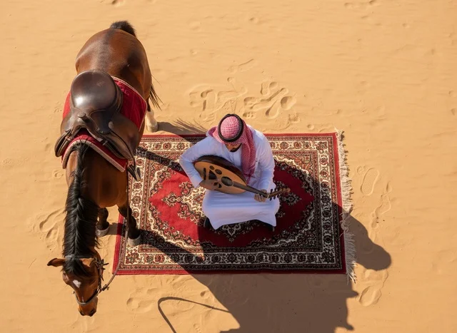 Saudi Man Playing Oud in Desert with Horse