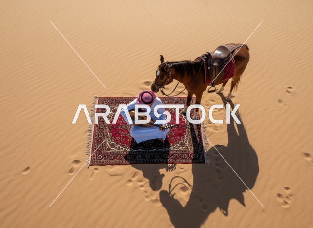 رجل سعودي يعزف العود مع خيل في الصحراء