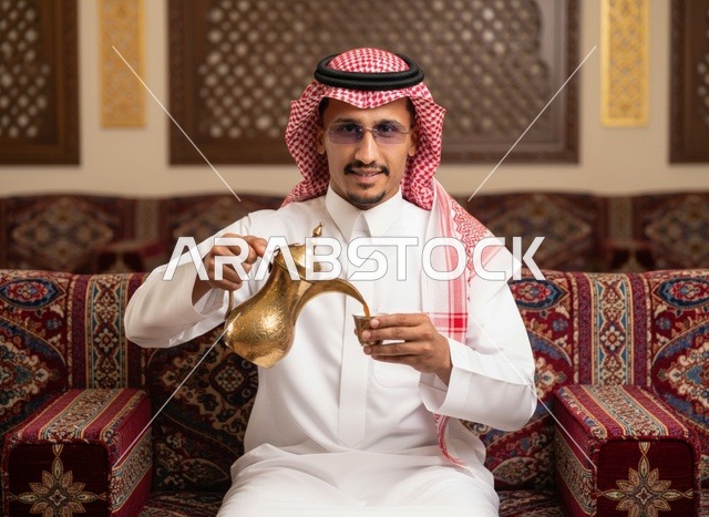 رجل سعودي يصب القهوة العربية في مجلس تقليدي