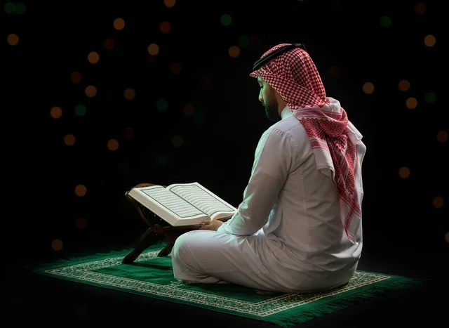 Saudi Man Reading Quran on Prayer Rug at Night