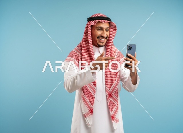 رجل سعودي يشير إلى هاتف ذكي بخلفية زرقاء