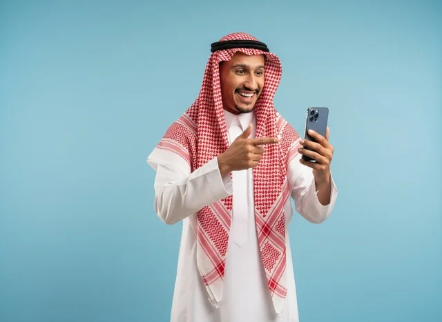 Saudi Man Pointing at Smartphone on Blue Background