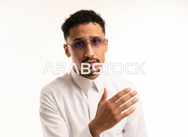 رجل سعودي بالثوب الأبيض ونظارات شمسية في الاستوديو