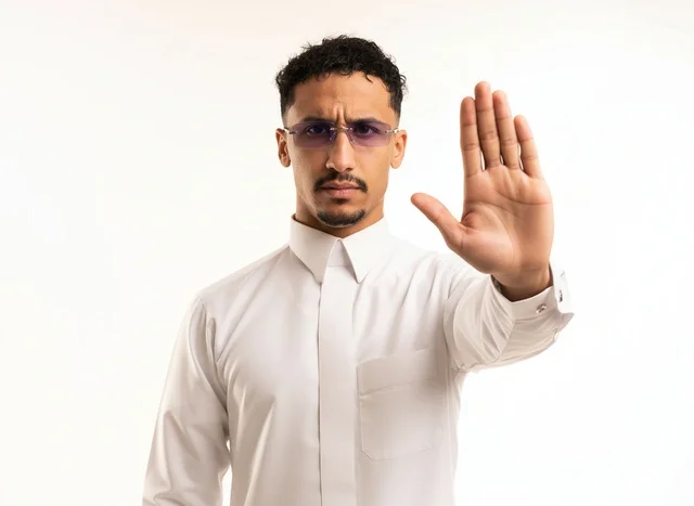 Saudi Man in Traditional White Thobe Making Stop Gesture