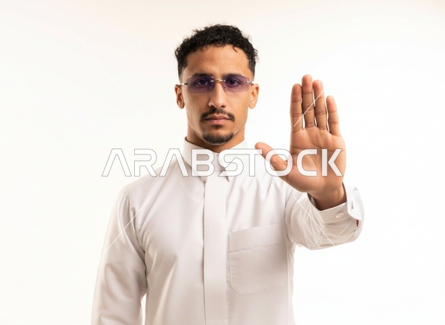 رجل سعودي بالثوب التقليدي يشير بعلامة التوقف