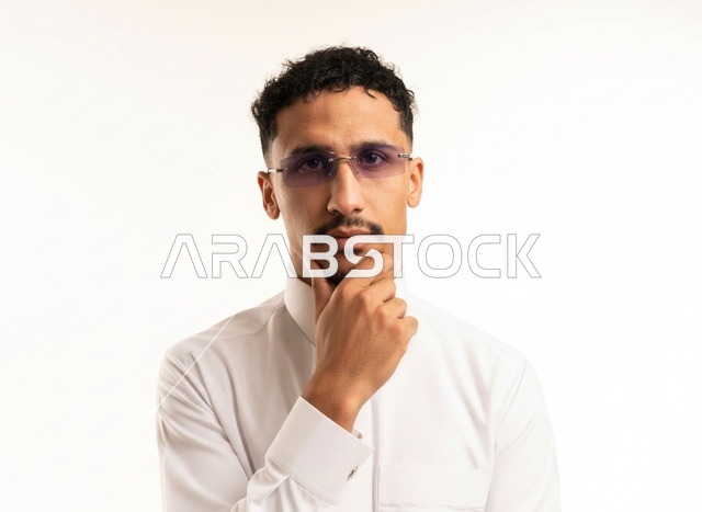 رجل سعودي بالثوب الأبيض في وضعية تفكير