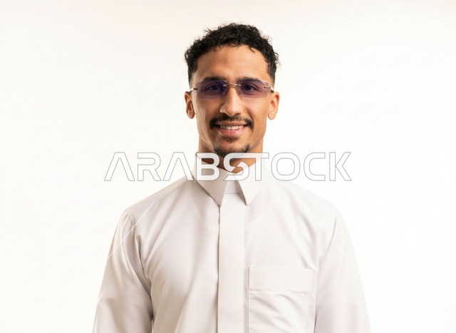 رجل سعودي مبتسم بالثوب الأبيض والنظارات