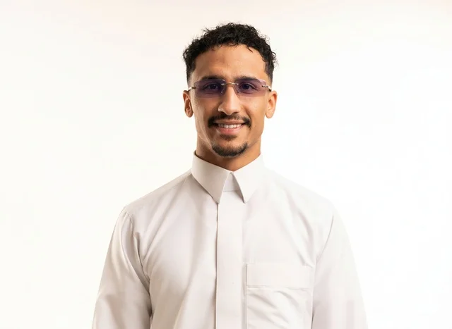 رجل سعودي مبتسم بالثوب الأبيض والنظارات