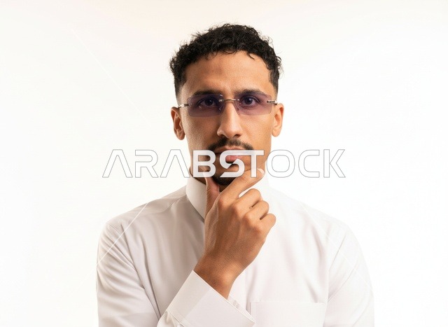 رجل سعودي بالثوب الأبيض يفكر أمام خلفية بيضاء