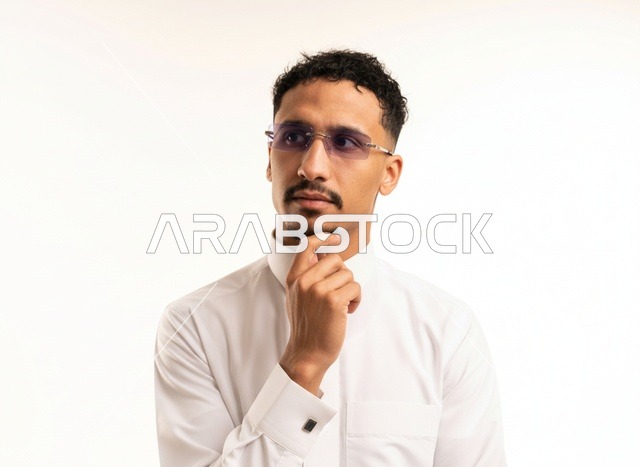 رجل سعودي بالثوب الأبيض بتعبير مفكر
