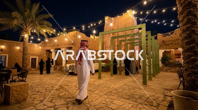 رجل سعودي بالزي التقليدي في موقع تراثي ليلاً