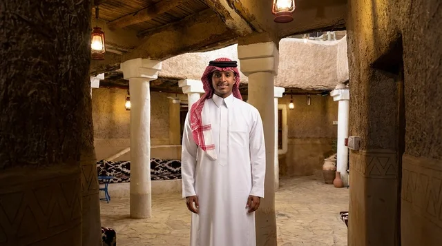 Saudi Man in Traditional Mud House with White Pillars