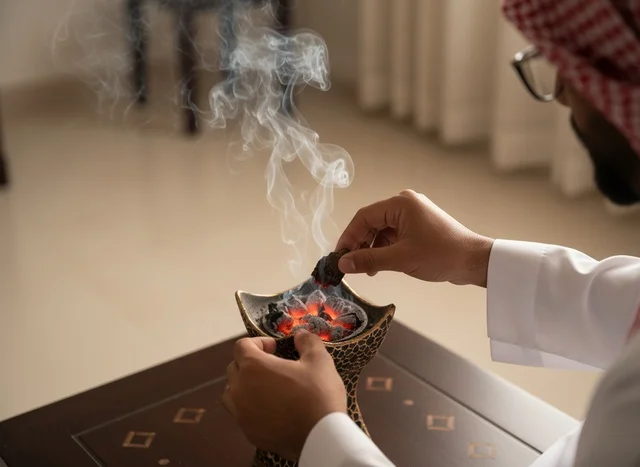 رجل سعودي يضع عود البخور في المبخرة التقليدية