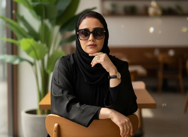امرأة سعودية بالعباءة السوداء في مقهى حديث