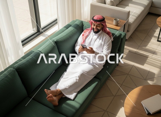 Saudi Man on Sofa Using Smartphone in Modern Home