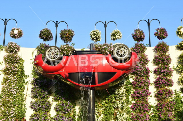 سيارة حمراء كلاسيكية مقلوبة على شكل شلال في الحديقة المعجزة بدبي في الإمارات العربية المتحدة، مناظر خلابة، معالم دبي المشهورة، سيارة كلاسيكية، الحديقة المعجزة، السياحة في الإمارات