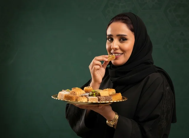 Saudi Woman with Arabic Sweets on Green Background