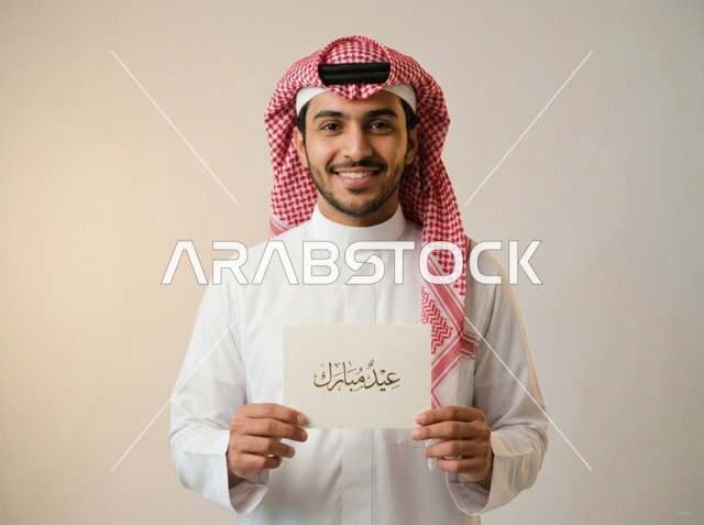 شاب سعودي يحمل بطاقة تهنئة عيد مبارك