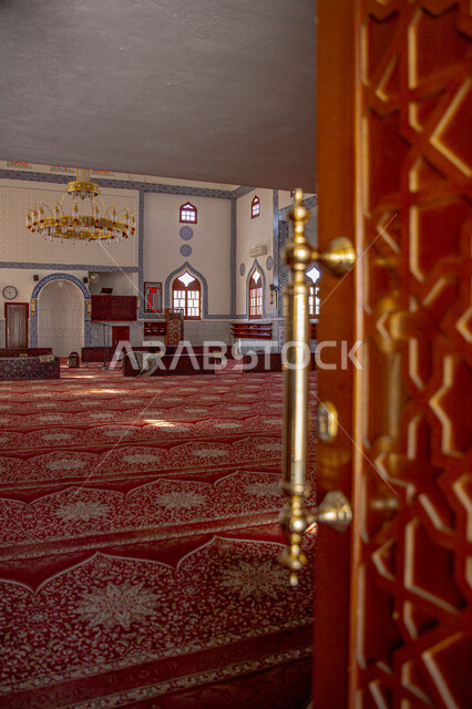 صورة من الداخل لاحد المسجد في المملكة العربية السعودية، التصميم الهندسي المعماري المميز، العبادة والتقرب الى الله، نجفة كبيرة، اقامة الصلاة، الفن الاسلامي المعماري في السعودية