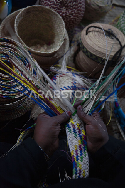 صورة ليد رجل عربي خليجي يقوم بجدل سعائف الخوص، اعمال وصناعات يدوية، حرفة يدوية تاريخية، التراث الخليجي، حرف شعبية