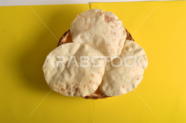 صورة مقربة لطبق يحتوي على الخبز العربي مصور على خلفية صفراء، مخبوزات ساخنة، الخبز العربي الصحي، مخابز عربية خليجية سعودية