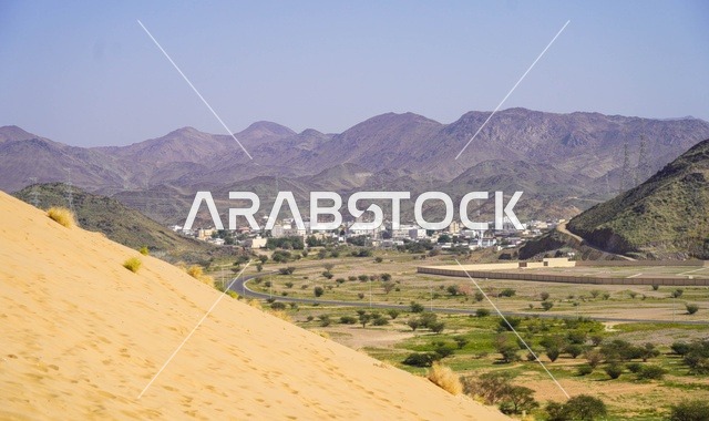 كثيب رملي وواد أخضر مع الجبال في المملكة العربية السعودية