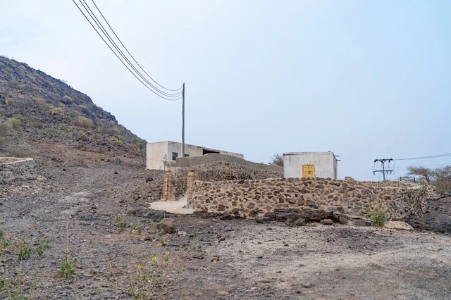 Rural Mountain Buildings Behind Stone Retaining Wall