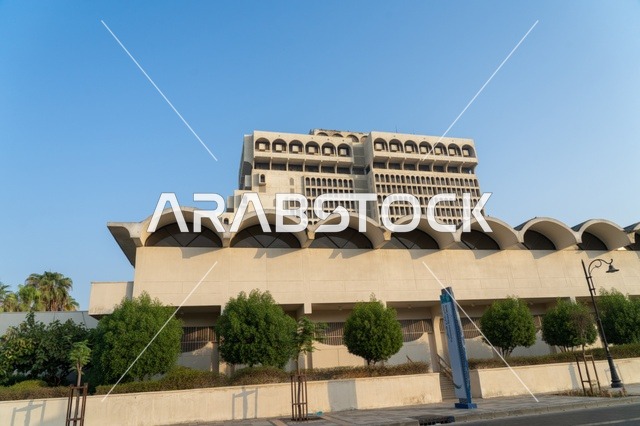 مبنى مؤسسي حديث بواجهة مقوسة في وضح النهار