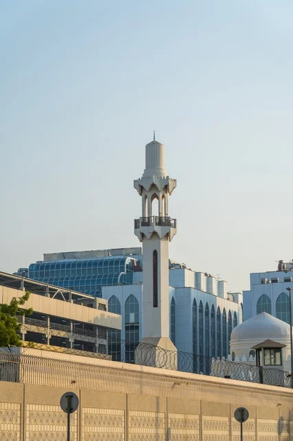 مئذنة مسجد بيضاء وسط مباني المدينة الحديثة