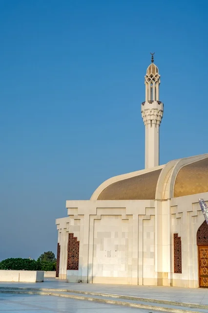 مسجد أبيض حديث مع مأذنة تحت السماء الزرقاء