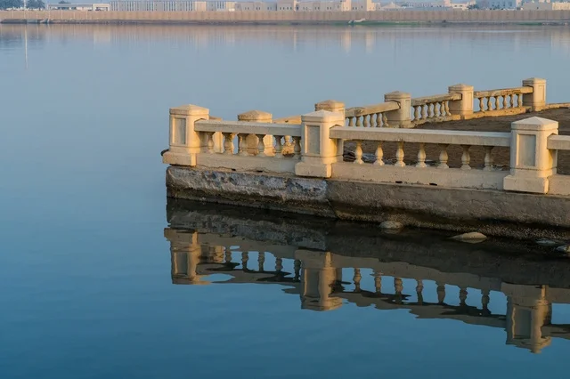 Waterfront Stone Balustrade with Reflection in Calm Water